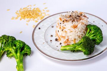 Rice with barley noodles and fresh broccoli on the plate.