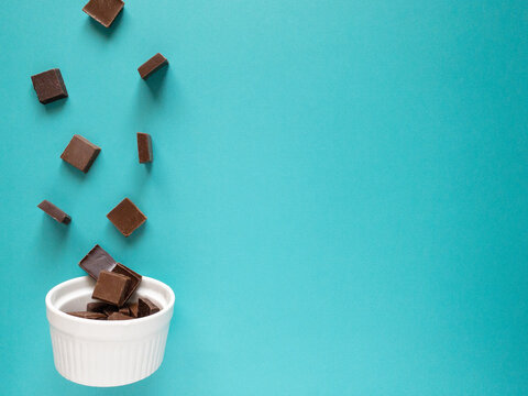 白いラムカンに向かって落ちるチョコレート 