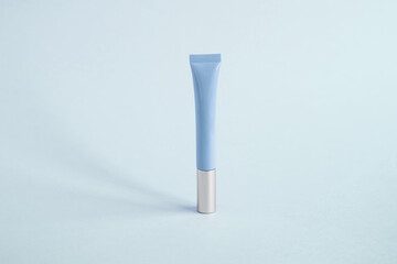 one tall narrow tube for cosmetics lip gloss, cream, blue on a blue background 