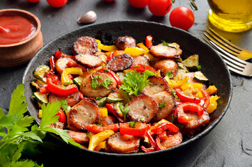 Slices of fried sausages with vegetables and spices