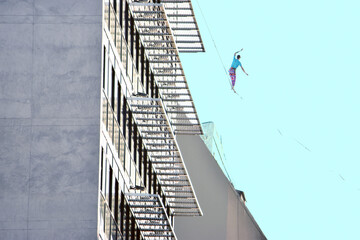 Fototapeta premium equilibrista rascacielo cuerda pekigro gente