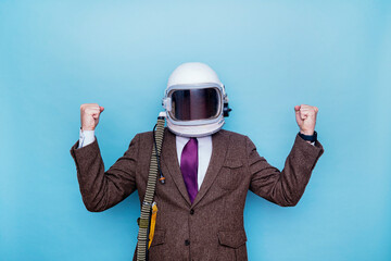 Businessman with astronaut helmet celebrating euphoric raising fists