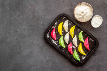 Colorful dumplings tortellini on baking sheet, top view