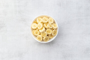 Banana slices in bowl. Fresh friuts top view