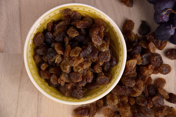 Dried raisins raisins in a bowl on the table top view stock images. Raisins sultanas still life photo images. Pile of raisins on a wooden background