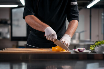 close up of chef cook hands in gloves cutting or chop yellow pepper at kitchen - Powered by Adobe
