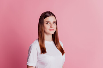 Fototapeta premium Young charming pretty cute girl look at camera on pink wall