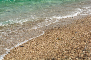 Soft turquoise sea wave on pebble beach. Nature background
