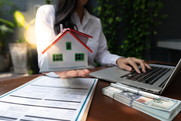 The real estate agent is explaining the house style to the clients who come to contact to see the house design and the purchase agreement.
