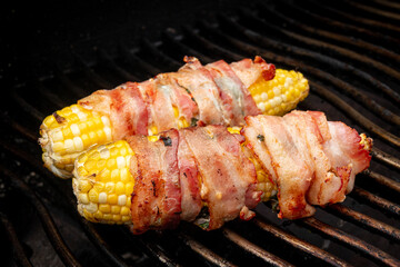 corn on the cob wrapped in bacon over the bbq grill