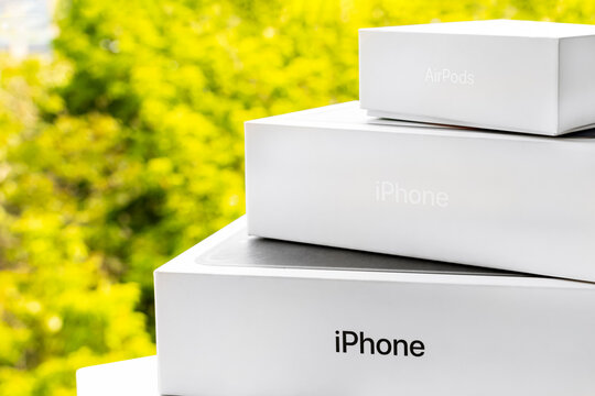 KYIV, UKRAINE - June 17, 2020: Boxes with Apple logo on a green background. apple inc. logo on the white retail boxes.