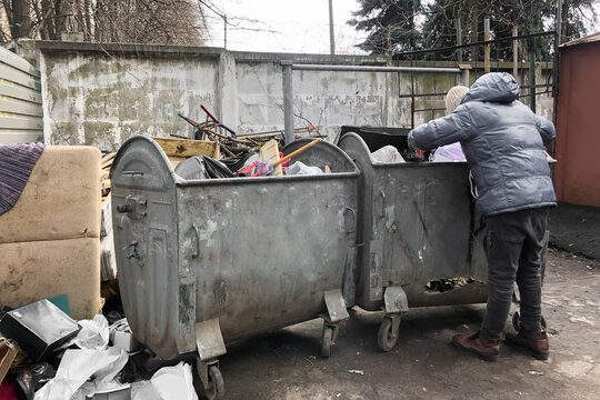 a man looking for food in garbage containers on the street. increase in unemployment due to quarantine and the COVID 19 pandemic