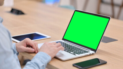 Fototapeta na wymiar Man Working on Laptop with Green Chroma Key Screen