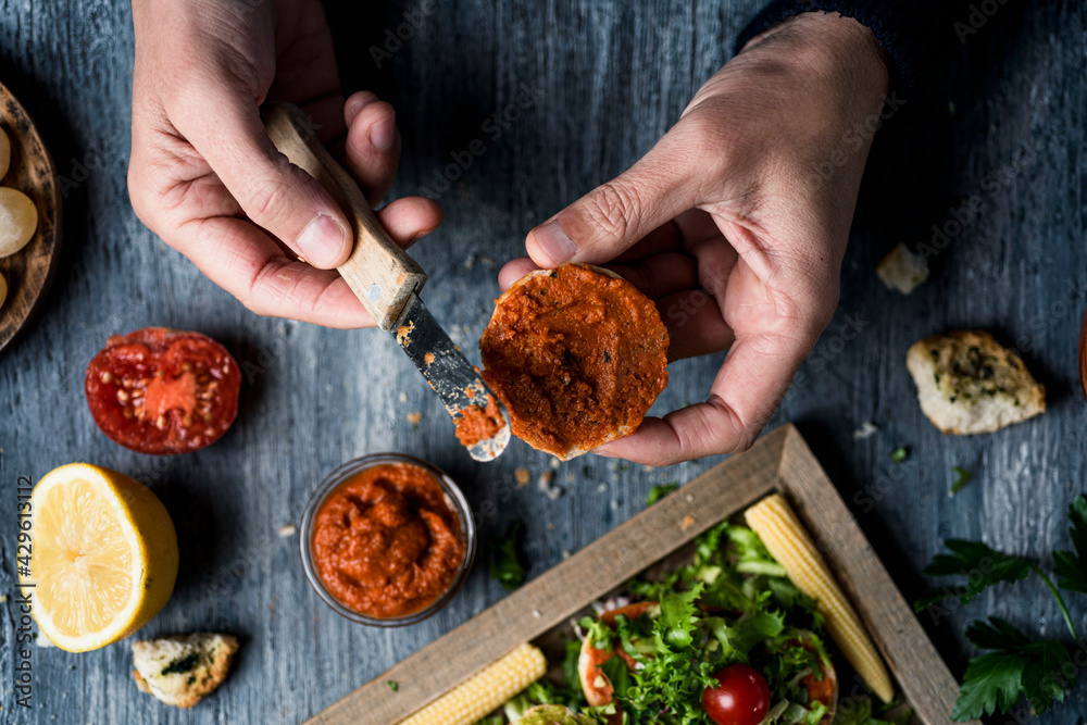 Poster spreads a vegan spread on halved toasted bun