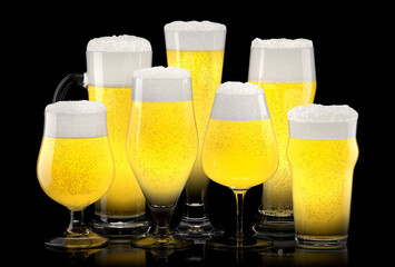 Set of fresh light beer glasses with bubble froth isolated on black background.
