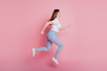 Fototapeta na wymiar Profile portrait of playful crazy girl jumping in the air wear casual denim outfit on pink wall