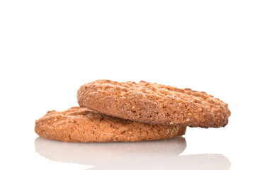 Two fragrant dark brown oatmeal cookies, close-up, isolated on white.