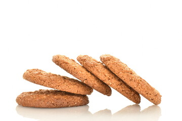 Several fragrant dark brown oatmeal cookies, close-up, isolated on white.