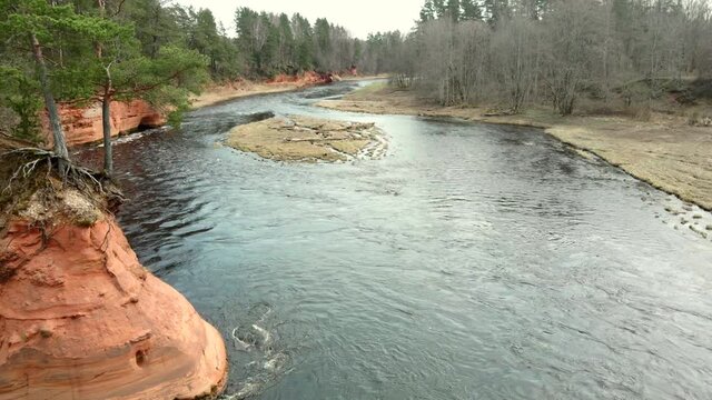 Red rocks and river Salaca. Sandstone cliff in Latvia, flying with drone in Gauja National Park