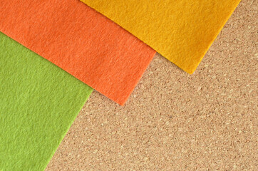 Orange and green and yellow felt fabric on the brown recycle board.