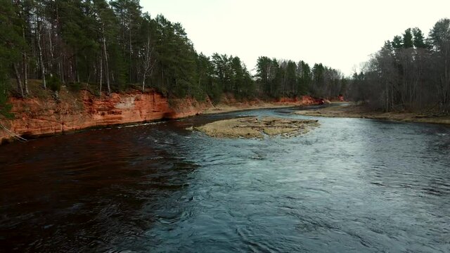 Red rocks and river Salaca. Sandstone cliff in Latvia, flying with drone in Gauja National Park