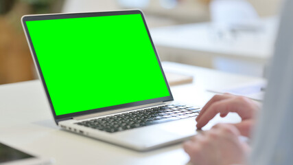 Fototapeta na wymiar Rear View of Young Man using Laptop with Chroma Screen 