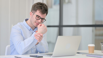 Young Man with Laptop having Wrist Pain 