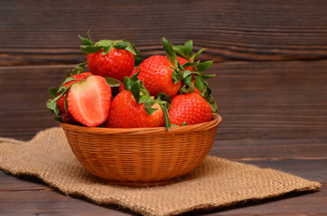 still life in a rustic style basket with strawberries on sackcloth