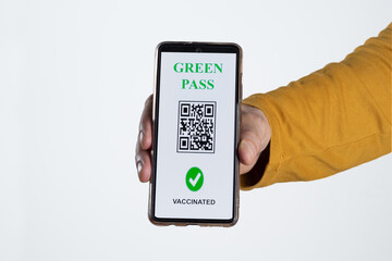 The digital green pass of the european union with the QR code on the screen of a mobile held by a hand with white background. Immunity from Covid-19. Travel without restrictions.