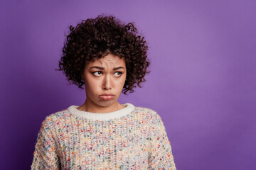 Beautiful unhappy girl grumpy look side empty space frowning isolated on violet background