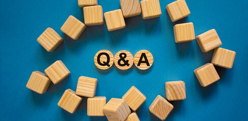 Q and A, questions and answers symbol. Concept text 'Q and A, questions and answers' on wooden circles on a beautiful blue background. Business, Q and A, questions and answers concept. Copy space.