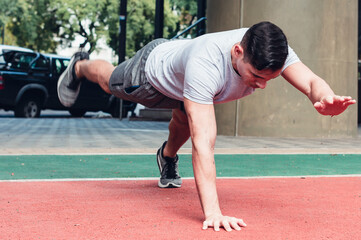 Fototapeta premium Young, athletic man doing push-ups. outdoors
