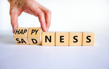 Happyness or sadness symbol. Businessman turns cubes and changes the word 'sadness' to 'happyness'. Beautiful white background. Business, psychological and happyness or sadness concept. Copy space.