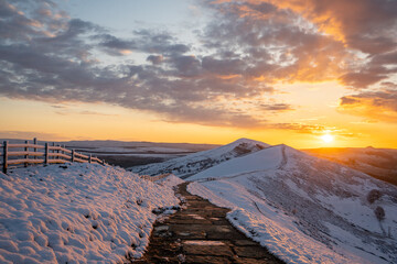 Stunning winter snowcapped mountain range hills summit sunrise. Mam Tor Derbyshire Peak District...