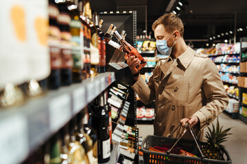 Man shopping in supermarket in mask during quarantine