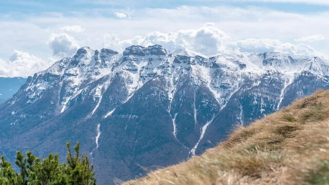 Timelapse 4K of clouds rolling on the top of mountains with snow in Italy. Massicio della Vigona visit Trentino Alto Adige Valsugana