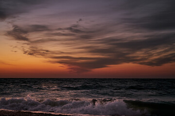 Fototapeta na wymiar Amazing gentle sunrise over the sea. Clouds in the rays of the rising sun. Dawn over the sea