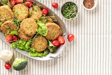metal dish with vegan vegetable burgers and salad on striped tablecloth. Healthy diet food concept. top view, copy space
