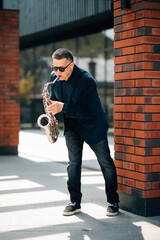 Middle age man playing on saxophone outside on the street