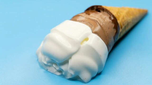 reverse of flower shape cocoa flavor ice cream cone melting time lapse close up on a blue background