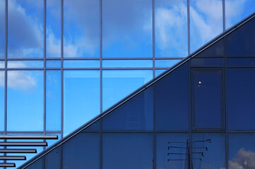 Windows on facade of modern building. Reflection of sky in windows glass.