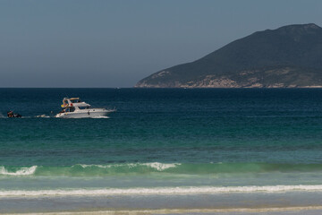 Fototapeta premium praia com montanhas, iates, rochas e lindas ondas