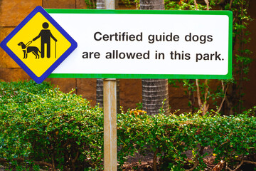 Certified guide dog sign for visually impaired on the old signpost in public park area