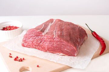 Large piece of raw veal meat on a light background, fresh fillet on a cutting board.