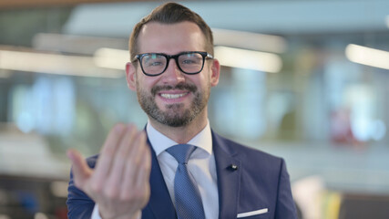 Fototapeta premium Portrait of Middle Aged Businessman Pointing at Camera, Inviting 