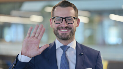 Portrait of Middle Aged Businessman Waving, Welcoming