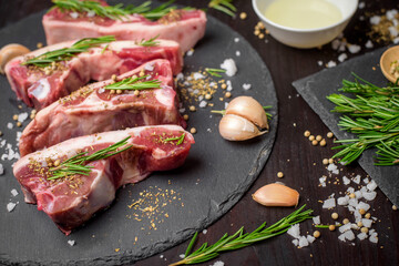 Fresh raw  beef and ingredients steak on black stone board over black wooden table