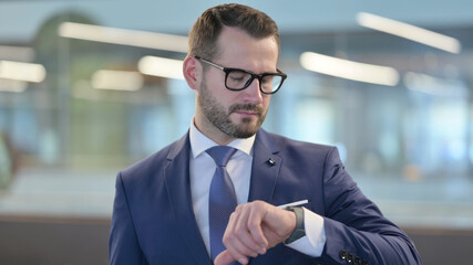 Portrait of Middle Aged Businessman using Smartwatch 