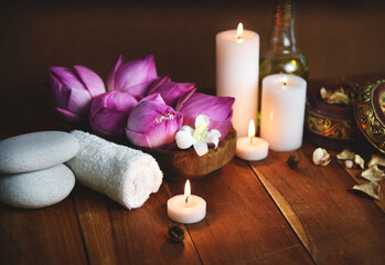 Obraz na płótnie Canvas Beauty products with Towel, candles and white stone on wooden background. Beauty spa treatment and relax concept.