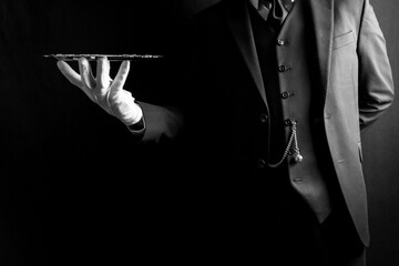 Portrait of Butler or Waiter in Dark Suit and White Gloves Holding Silver Tray. Concept of Service Industry and Professional Hospitality.